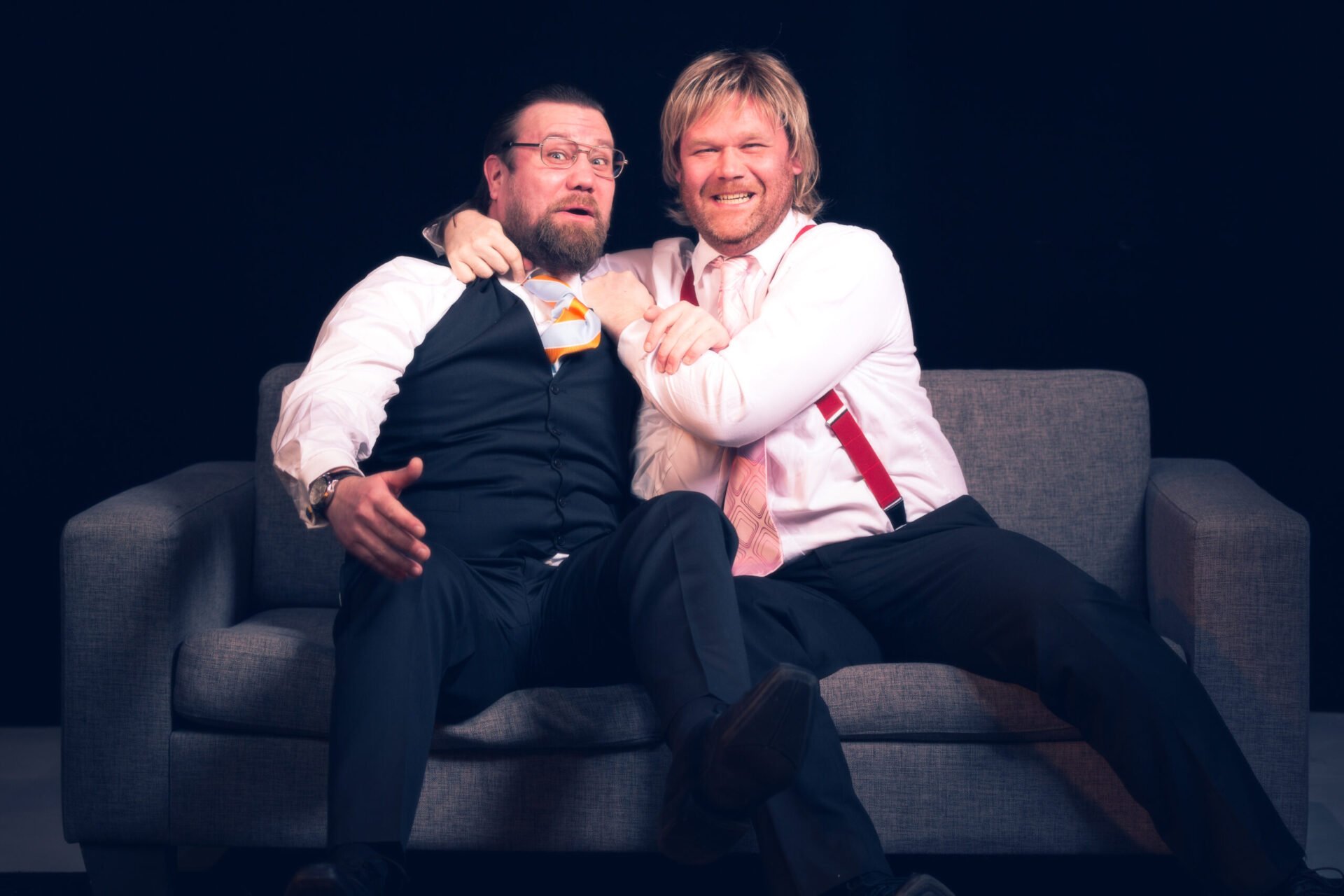 Kim Sørensen og Cato Skimten Sørengen sitter i en sofa og ler.
