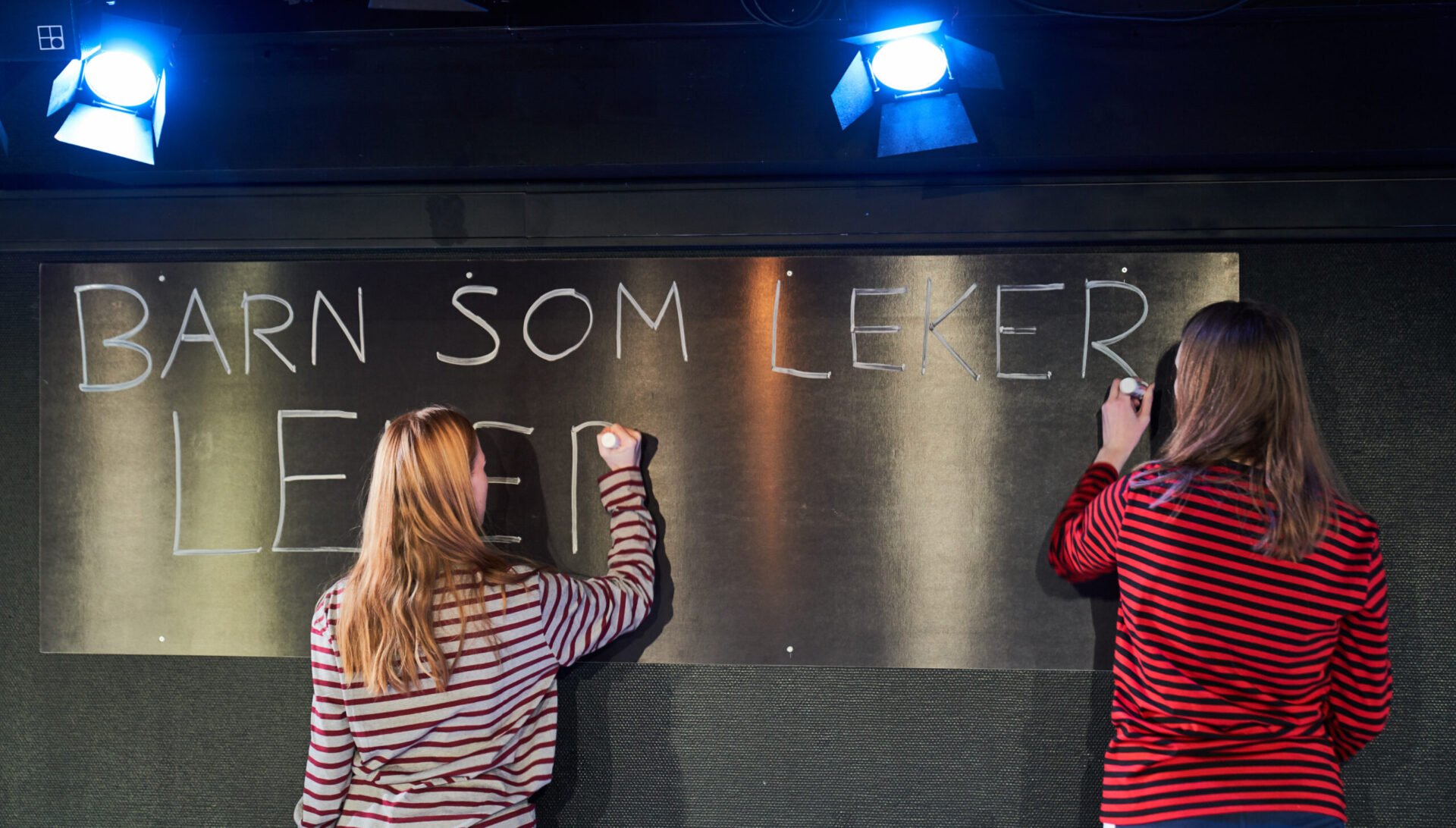 To jenter skriver på ei tavle.