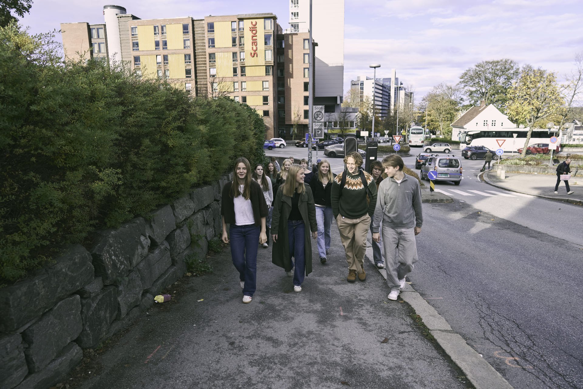 En gruppe ungdommer går opp en bakke mot kamera.