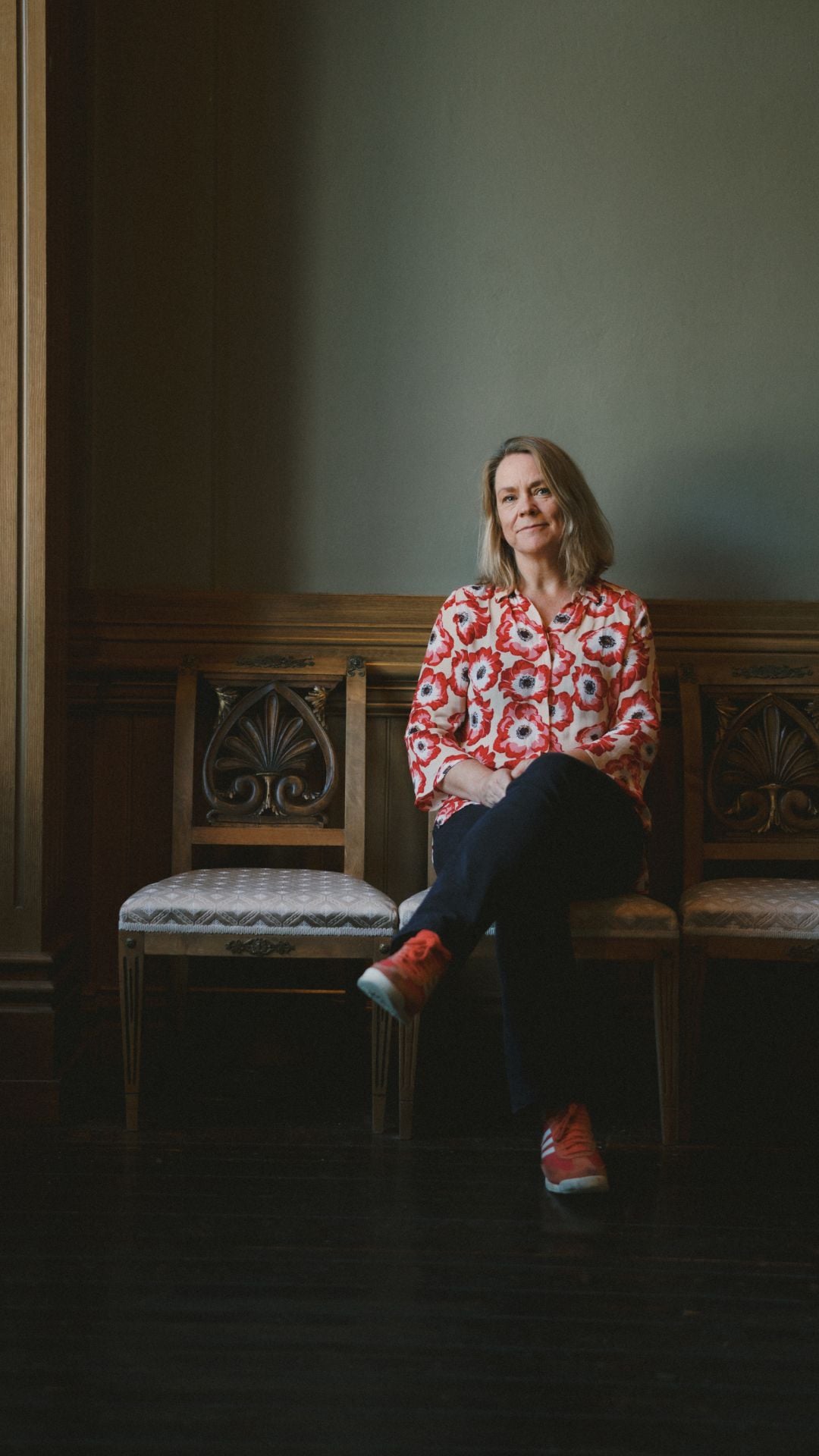 Mette Tveit sitter inne på en eldre stol.