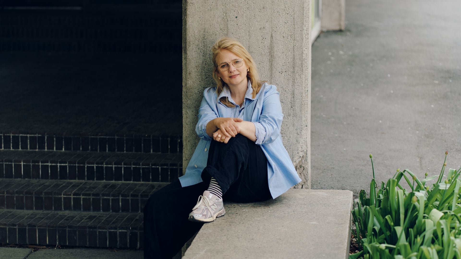 Victoria Meirik sitter lent mot en betongsøyle.