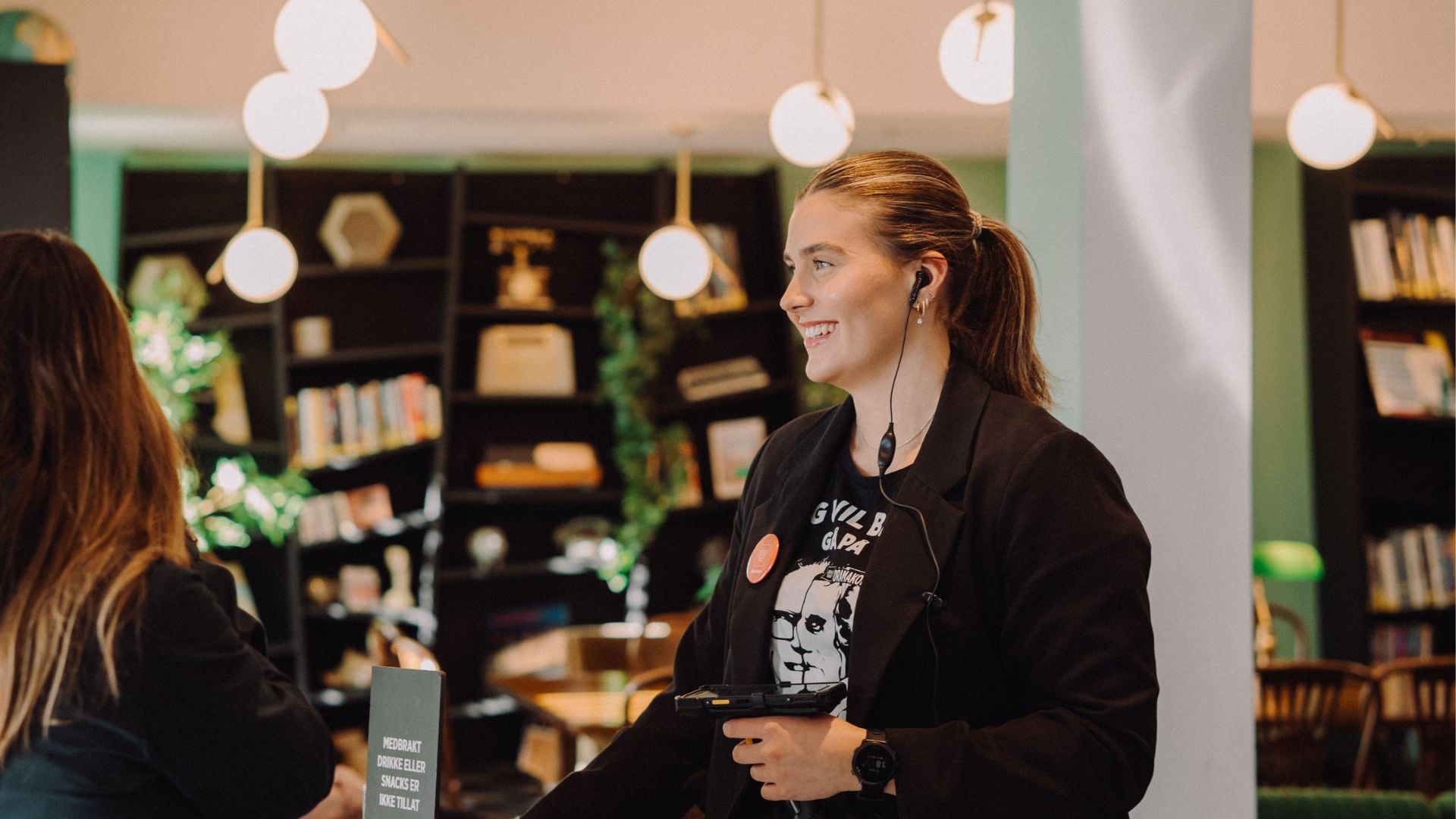 Lone Halle ønsker publikum velkommen i døren.